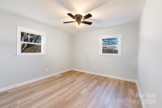 empty room with light hardwood / wood-style flooring, ceiling fan, and plenty of natural light