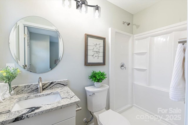 bathroom featuring walk in shower, vanity, and toilet