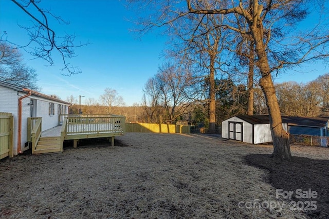 view of yard with a wooden deck and a storage unit