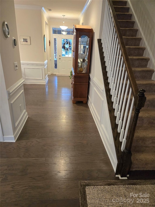 entrance foyer featuring dark wood-style floors, stairway, ornamental molding, and a decorative wall