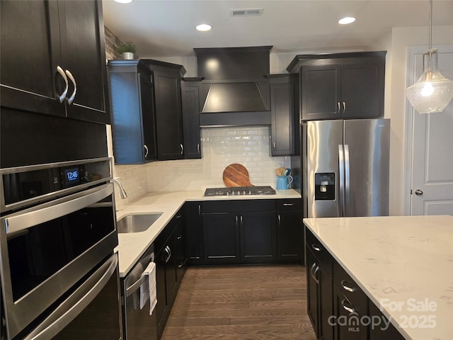 kitchen featuring stainless steel appliances, visible vents, dark cabinets, and decorative backsplash