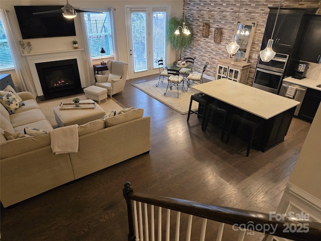 living area featuring a glass covered fireplace and wood finished floors