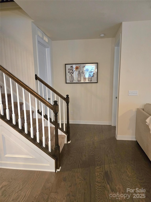 stairway with baseboards and wood finished floors