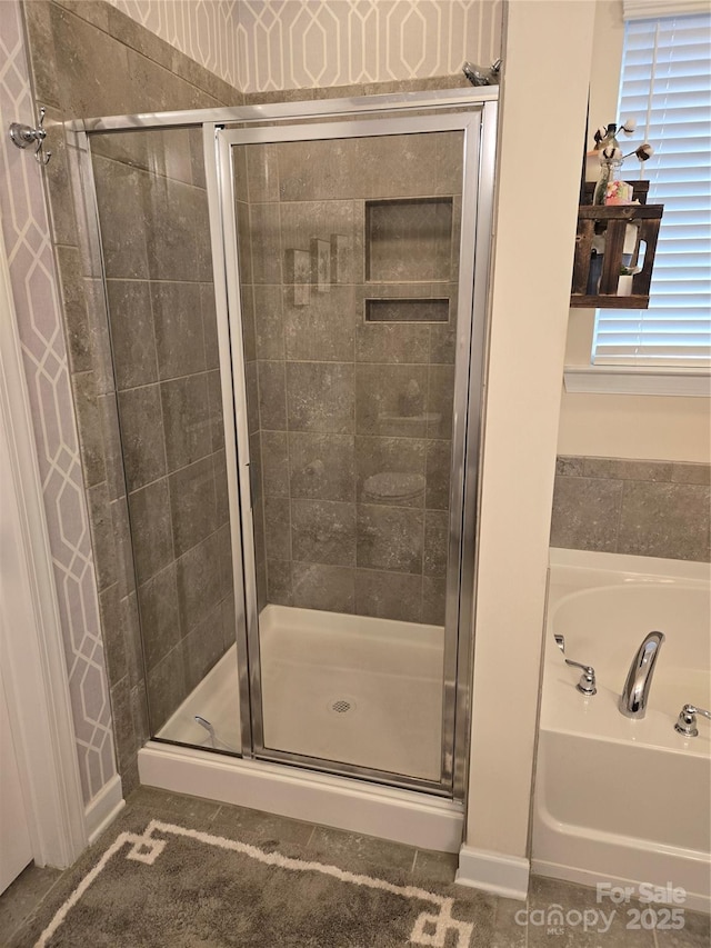 bathroom with a stall shower and a bath