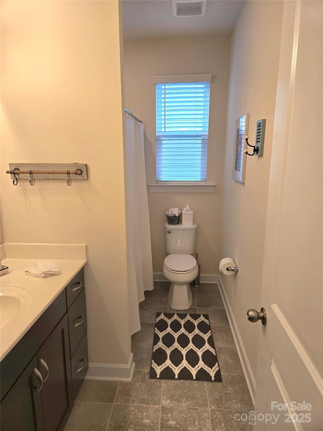 bathroom featuring baseboards, visible vents, vanity, and toilet