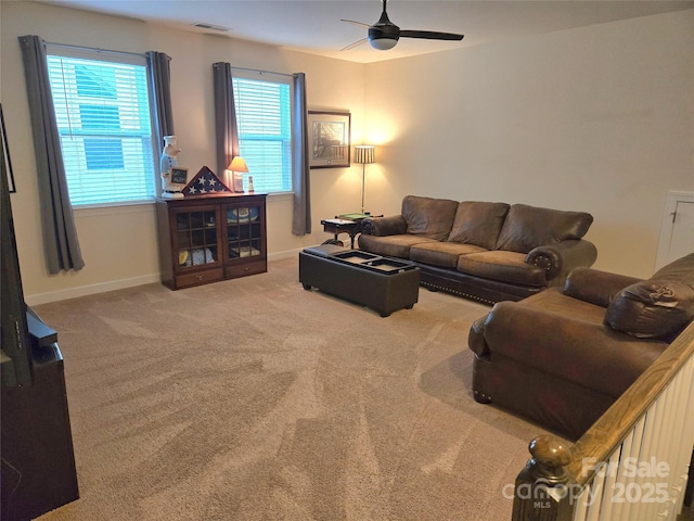 carpeted living room featuring visible vents, baseboards, and a ceiling fan