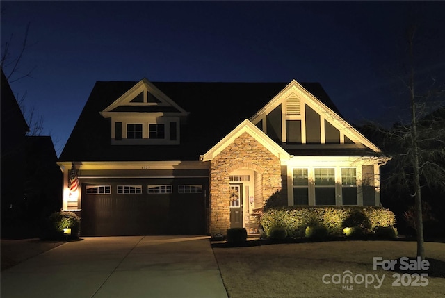 craftsman-style home with a garage, stone siding, and concrete driveway