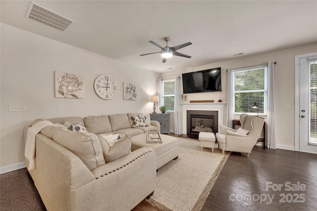 4929 Norman Park Pl, Clover, SC 29710 - living room featuring a glass covered fireplace, baseboards, visible vents, a ceiling fan, and dark wood-type flooring