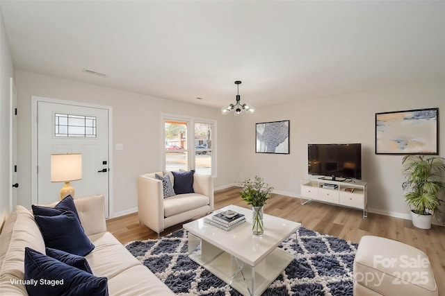 living room featuring an inviting chandelier and light hardwood / wood-style floors