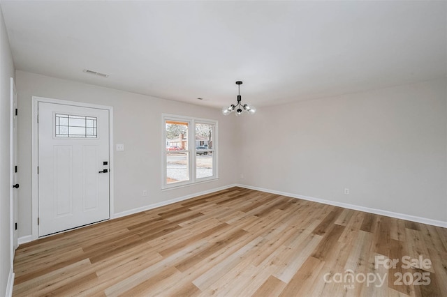 foyer featuring light wood-style floors, a chandelier, visible vents, and baseboards