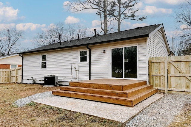 rear view of property featuring central AC unit, crawl space, a gate, fence, and a wooden deck