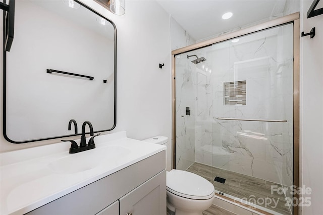 bathroom with recessed lighting, a marble finish shower, vanity, and toilet