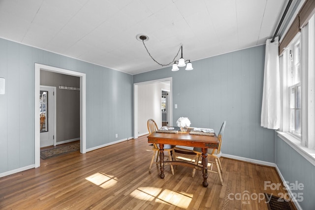 dining space with wood-type flooring and a chandelier