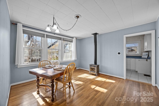 dining room featuring light hardwood / wood-style flooring and a wood stove