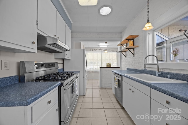 kitchen with hanging light fixtures, appliances with stainless steel finishes, sink, and white cabinets