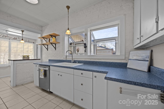 kitchen with white cabinetry, sink, pendant lighting, and stainless steel dishwasher