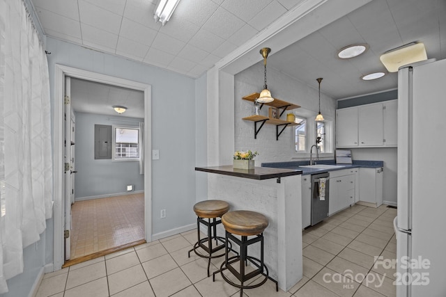 kitchen featuring white cabinetry, white refrigerator, a kitchen breakfast bar, dishwasher, and kitchen peninsula