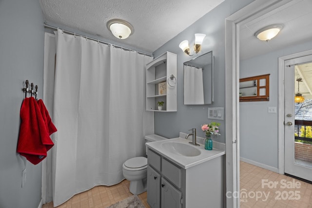 bathroom with vanity, toilet, and a textured ceiling