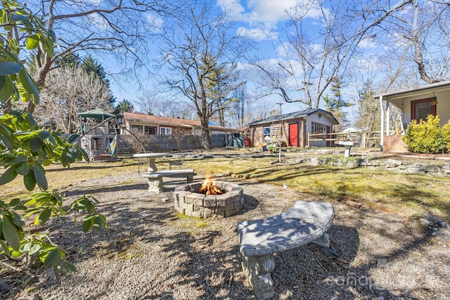 view of yard with a playground and an outdoor fire pit