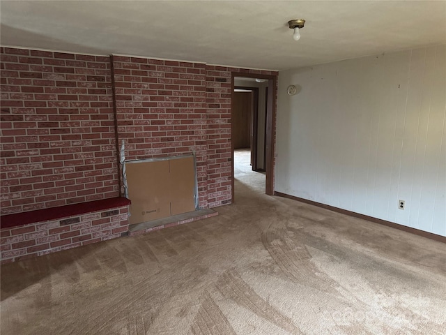 unfurnished living room featuring a fireplace, brick wall, and carpet flooring