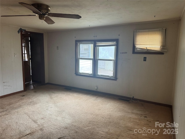 carpeted empty room featuring ceiling fan and a textured ceiling