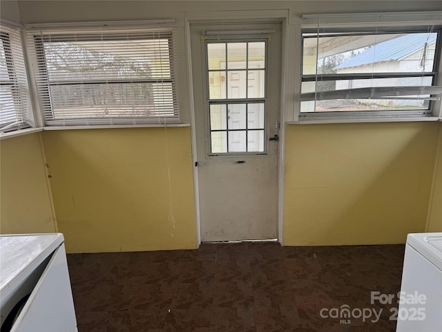 doorway featuring washer / clothes dryer and dark carpet