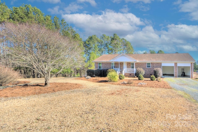 ranch-style home featuring a carport and covered porch