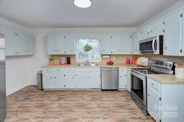 kitchen with sink, stainless steel appliances, and white cabinets