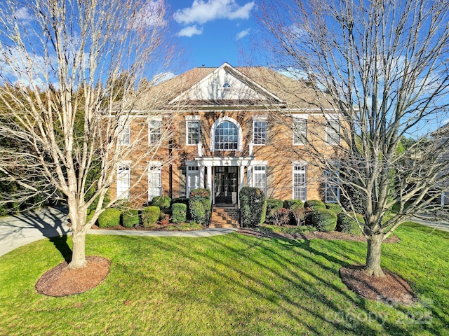 colonial house featuring a front lawn