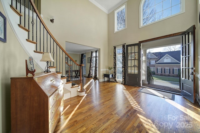 foyer with wood-type flooring and ornamental molding