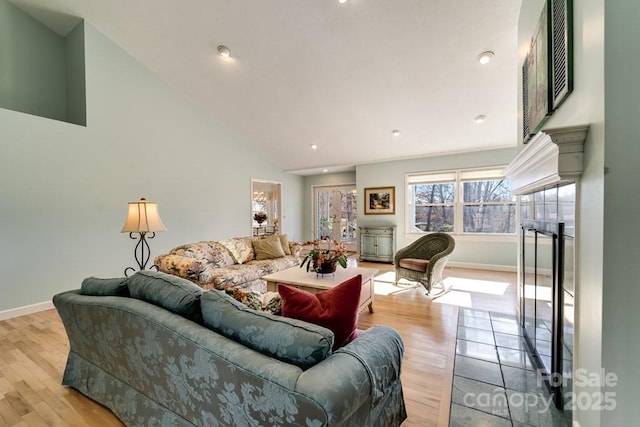 living room featuring high vaulted ceiling and light hardwood / wood-style floors