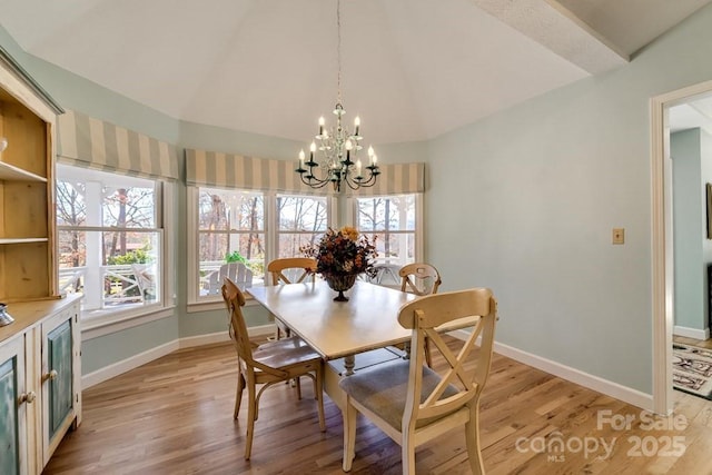 dining space with an inviting chandelier, vaulted ceiling, and light hardwood / wood-style floors