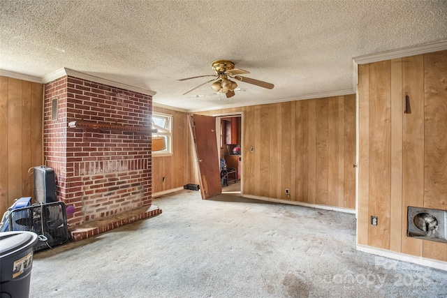 unfurnished living room with ornamental molding, wooden walls, light carpet, and a textured ceiling