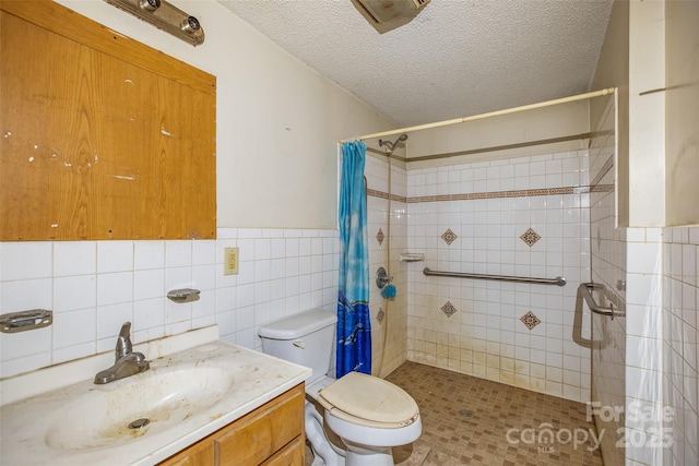 bathroom with tile walls, vanity, toilet, a textured ceiling, and a shower with curtain