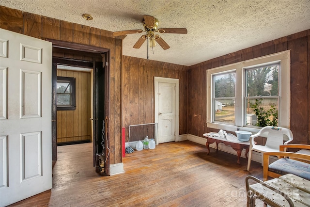 interior space with hardwood / wood-style flooring, a textured ceiling, and wood walls