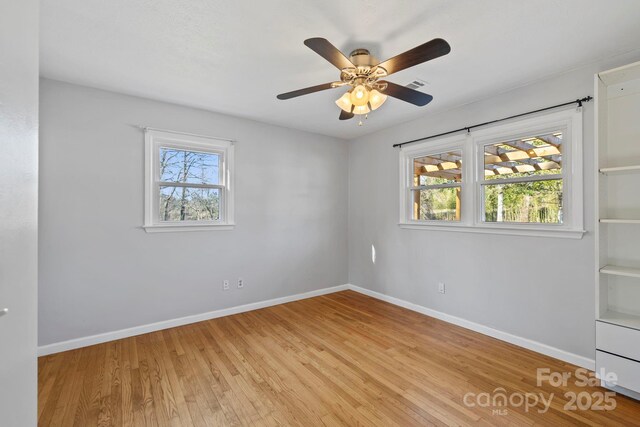 16 Rosscraggon Dr, Asheville, NC 28803 - empty room with a healthy amount of sunlight, ceiling fan, and light hardwood / wood-style flooring