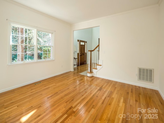 spare room featuring crown molding and light hardwood / wood-style flooring