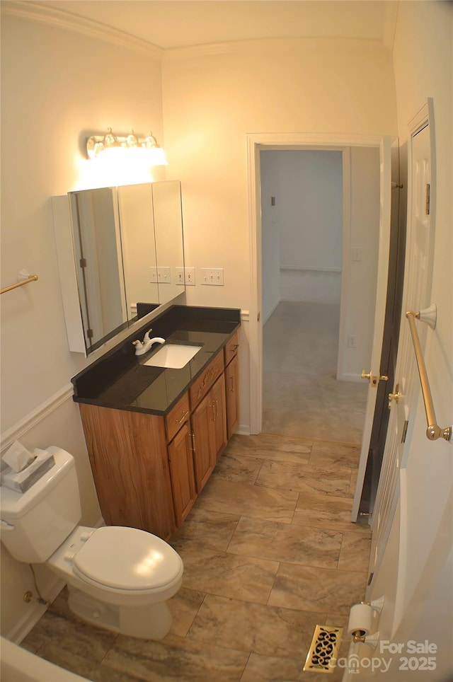 bathroom featuring vanity, ornamental molding, and toilet