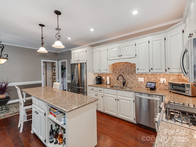 kitchen featuring stainless steel appliances, a center island, sink, and white cabinets