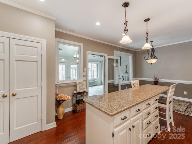 kitchen featuring light stone counters, a center island, dark hardwood / wood-style floors, a kitchen breakfast bar, and pendant lighting