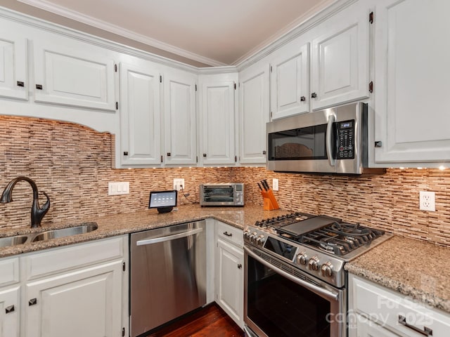 kitchen with white cabinetry, appliances with stainless steel finishes, sink, and light stone counters