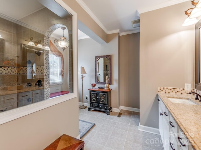 bathroom with vanity, tile patterned flooring, crown molding, and tiled shower