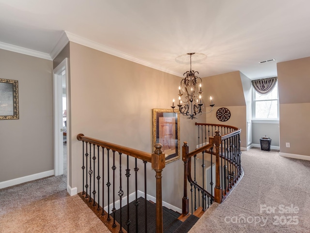 hall with an inviting chandelier, ornamental molding, and carpet flooring