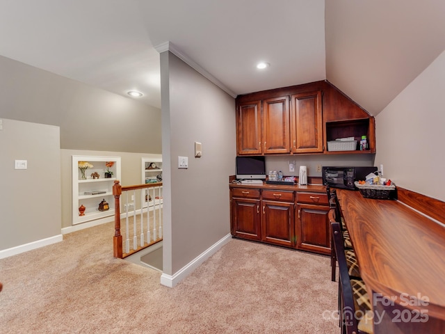 office area featuring lofted ceiling, light colored carpet, and built in shelves