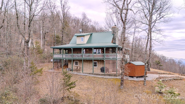 back house at dusk with a wooden deck and a storage unit