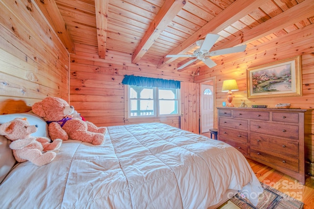 bedroom featuring wooden walls, beamed ceiling, hardwood / wood-style flooring, ceiling fan, and wooden ceiling