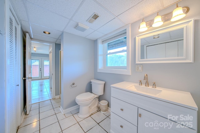 bathroom with tile patterned floors, vanity, a paneled ceiling, and a wealth of natural light