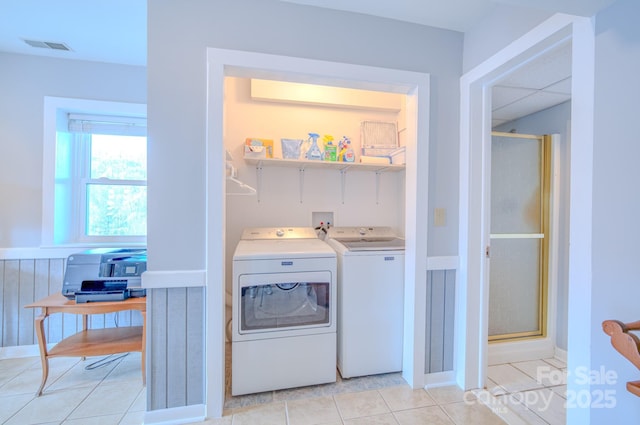 laundry area with light tile patterned flooring and washer and dryer