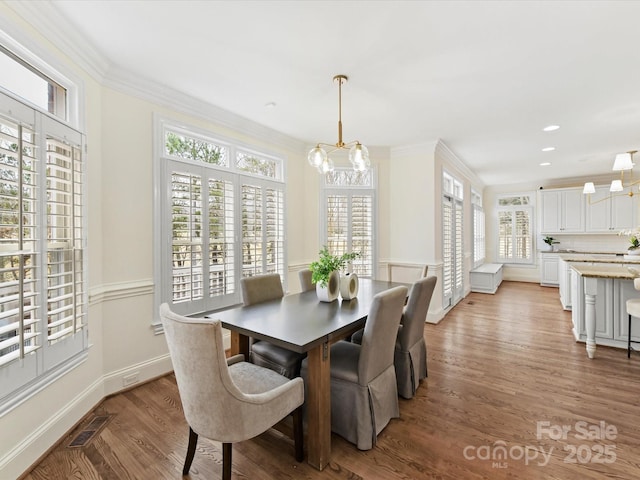 dining area featuring a notable chandelier, visible vents, and ornamental molding