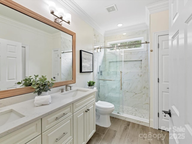 bathroom with a marble finish shower, wood finish floors, a sink, crown molding, and toilet